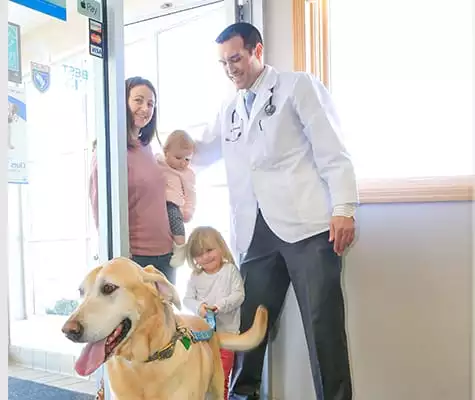 Veterinarian welcoming clients into the animal hospital